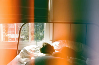 a person sleeping in bed on a sunny day