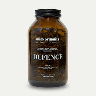 Defence tea infusion in a brown Welb Organics herbal tea jar on a neutral background