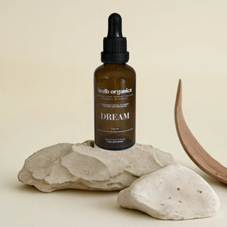 Bottle of 'Dream' on a stone surface with a neutral background