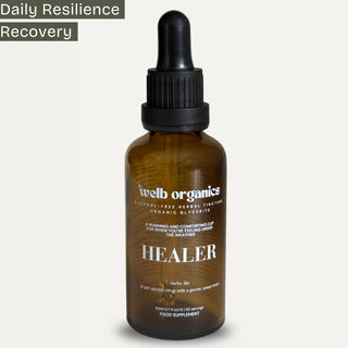 Brown glass bottle with dropper labeled 'welb organics Healer' on a white background