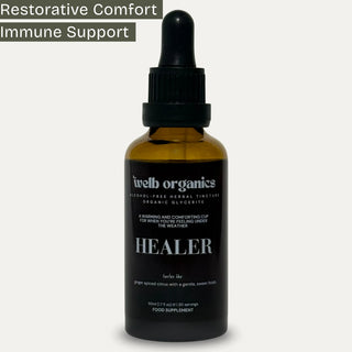 A dark amber glass dropper bottle labeled 'welb organics HEALER' on a light gray background, with a dark gray banner at the top reading 'Restorative Comfort Immune Support'.