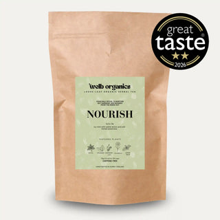 A kraft paper stand-up pouch of Well Organics Nourish loose leaf tea, featuring a light green label with black text. A black circular 'great taste 2026' award badge is positioned in the top right corner against a light grey background.
