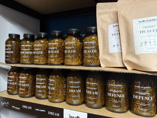 Shelves with jars and bags labeled 'welb organics' in a store setting.